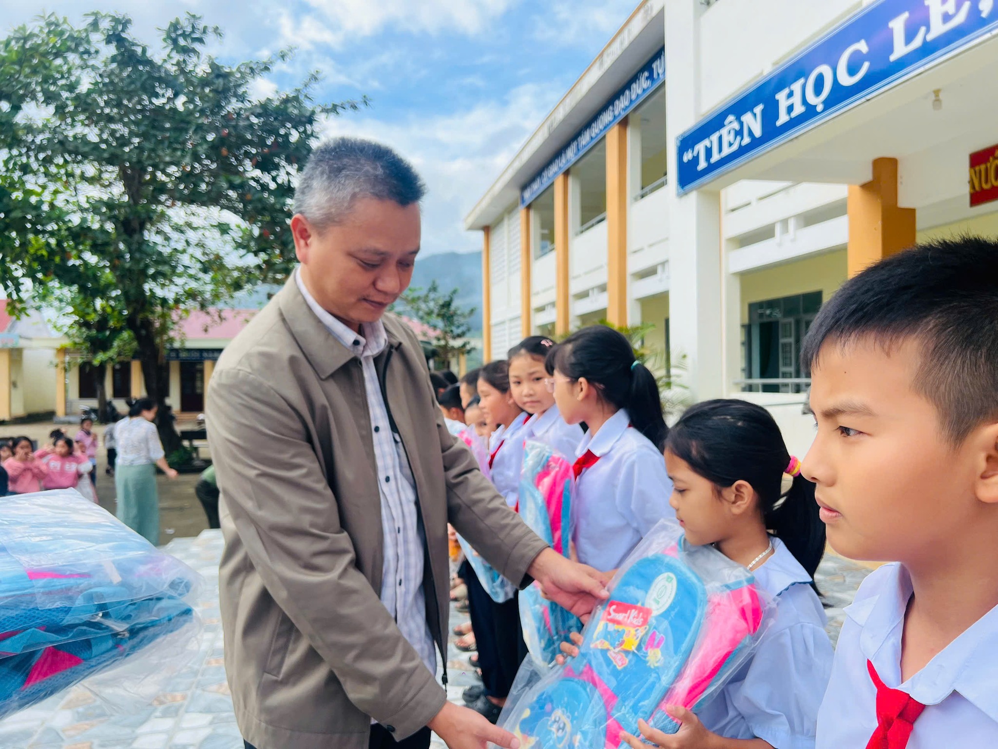 Đồng chí Trần Quốc Huy - Bí thư Đảng ủy xã tặng quà cho học sinh trường Tiểu học Đa Lộc